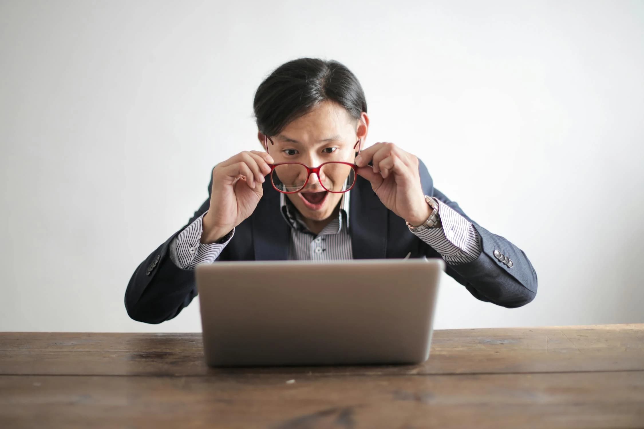 A woman with a shocked reaction to her laptop